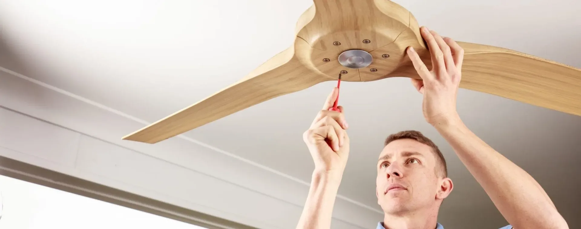 Electrician fitting a new ceiling fan