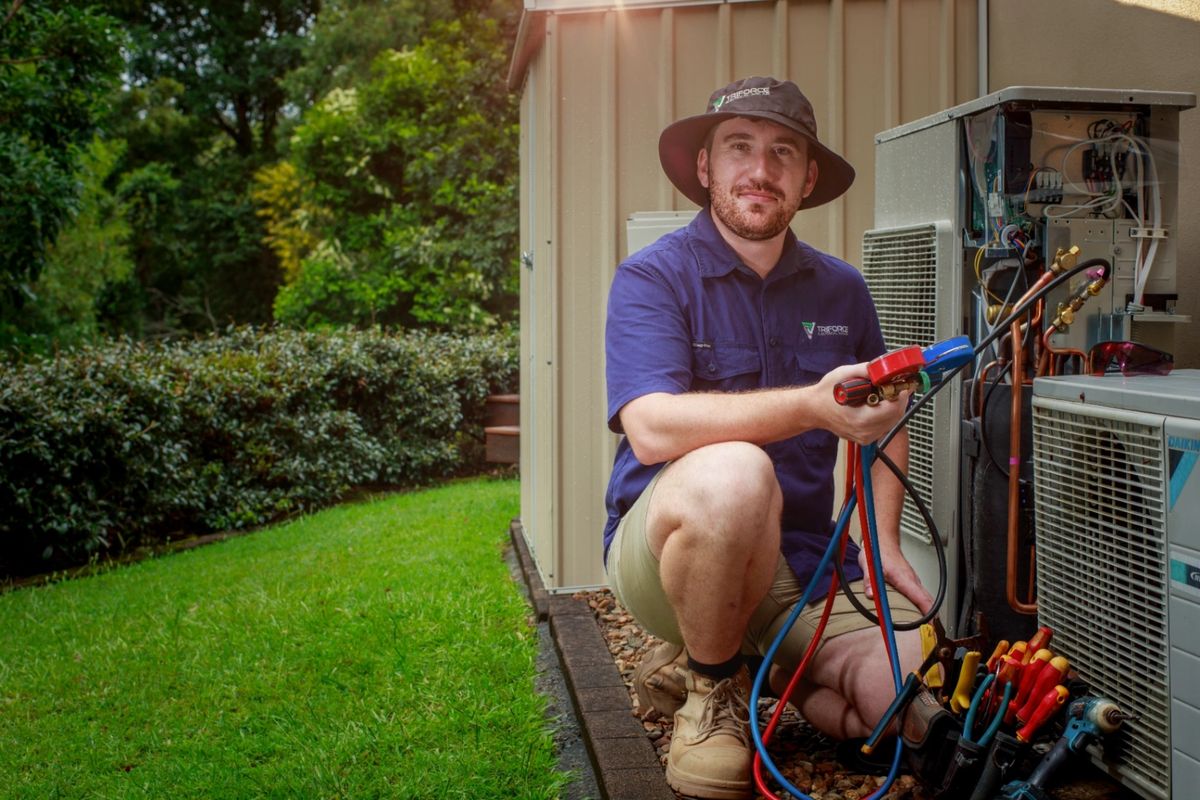 Triforce technician servicing a Daikin outdoor air conditioning unit