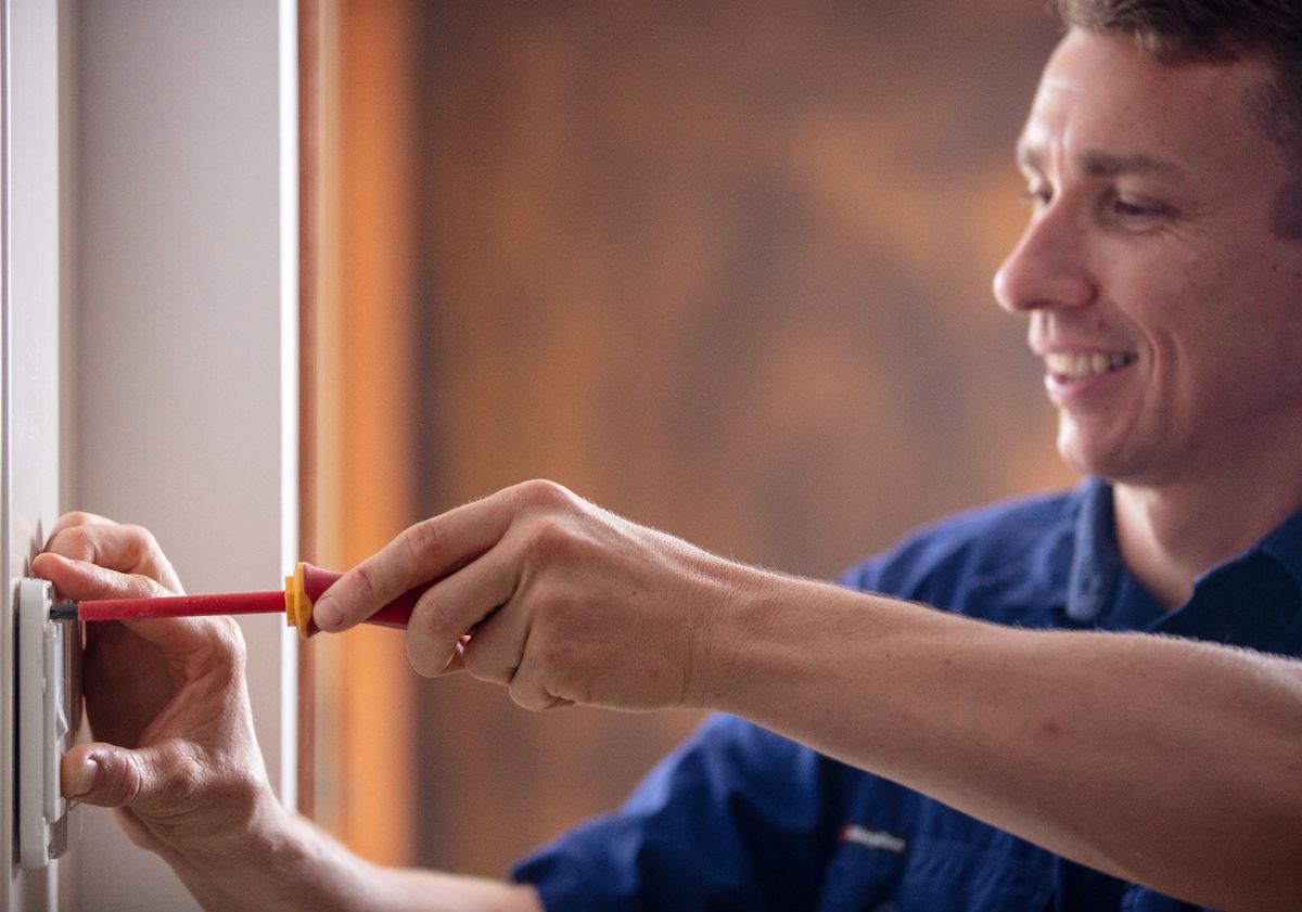 Triforce electrician installing a power point in a Shailer Park home