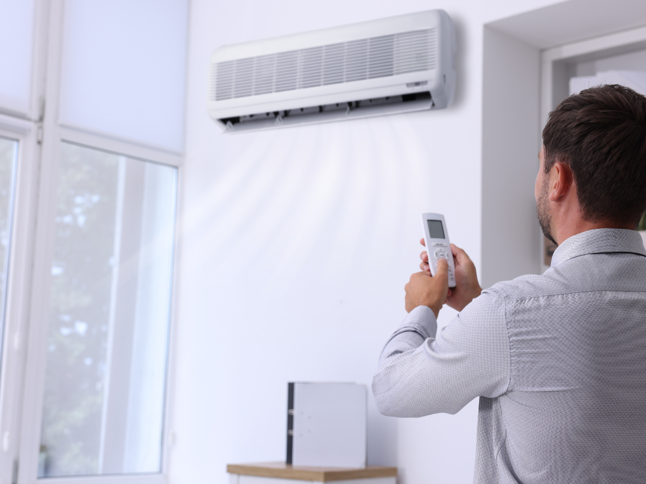 Technician adjusting the settings on a split system air conditioner during a repair
