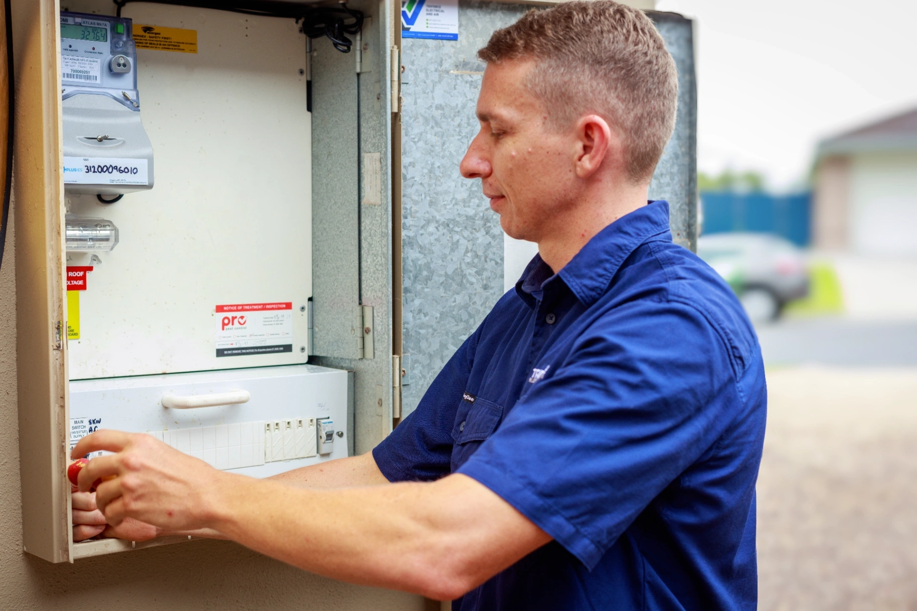 Electrician inspecting and testing a switchboard during an electrical safety inspection